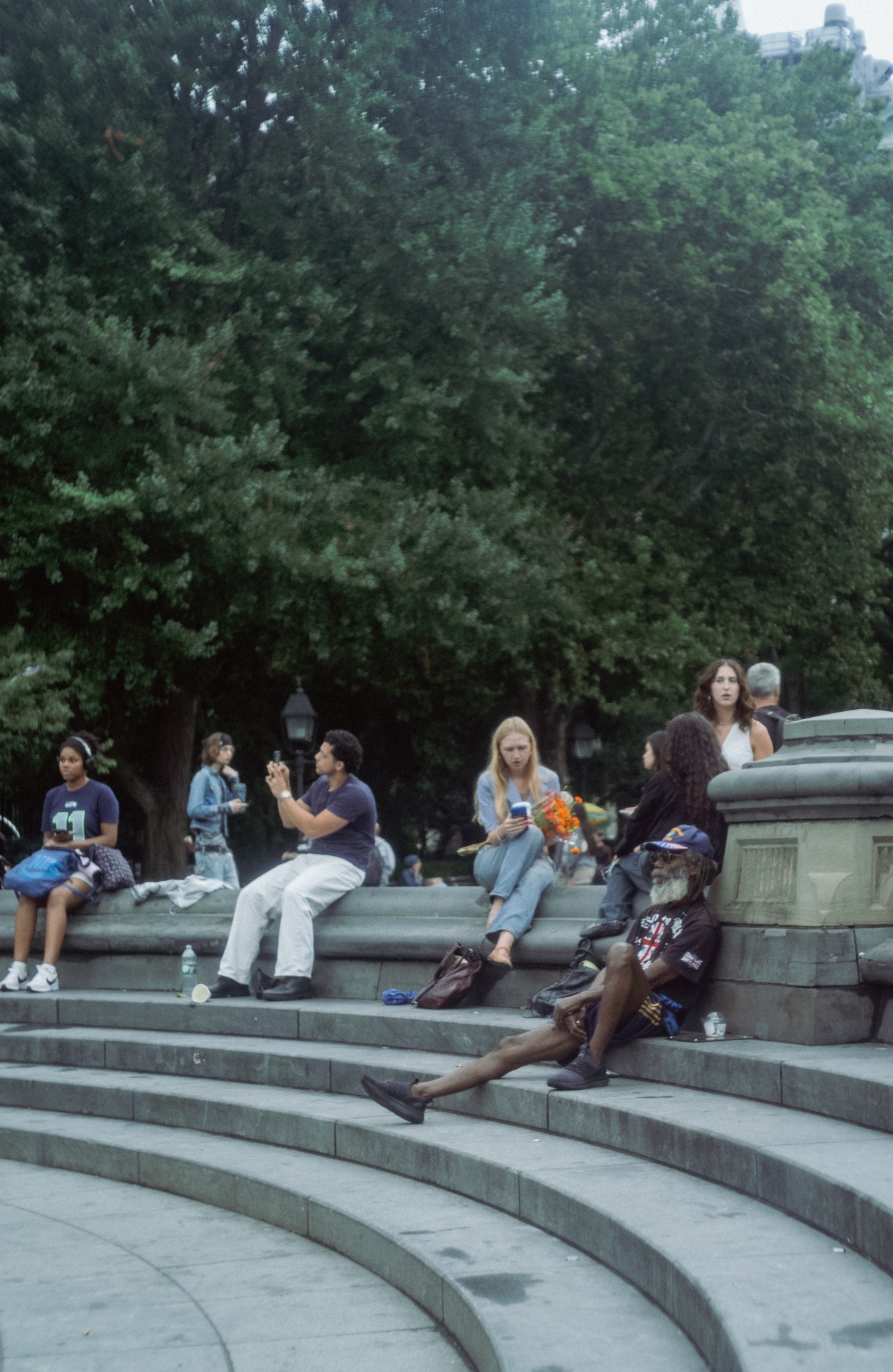 New York street photography downtown: people seated in Washington Square Park