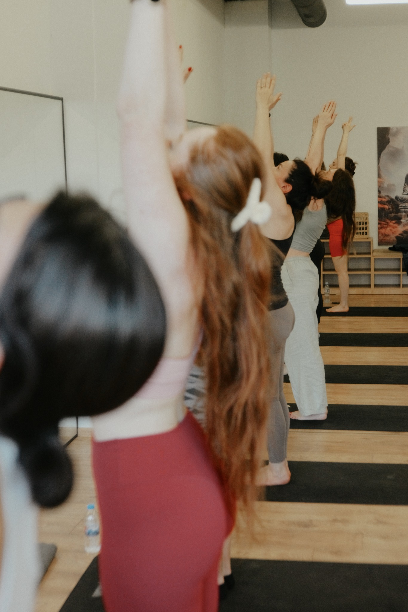 The class lifts their arms together, viewed from behind
