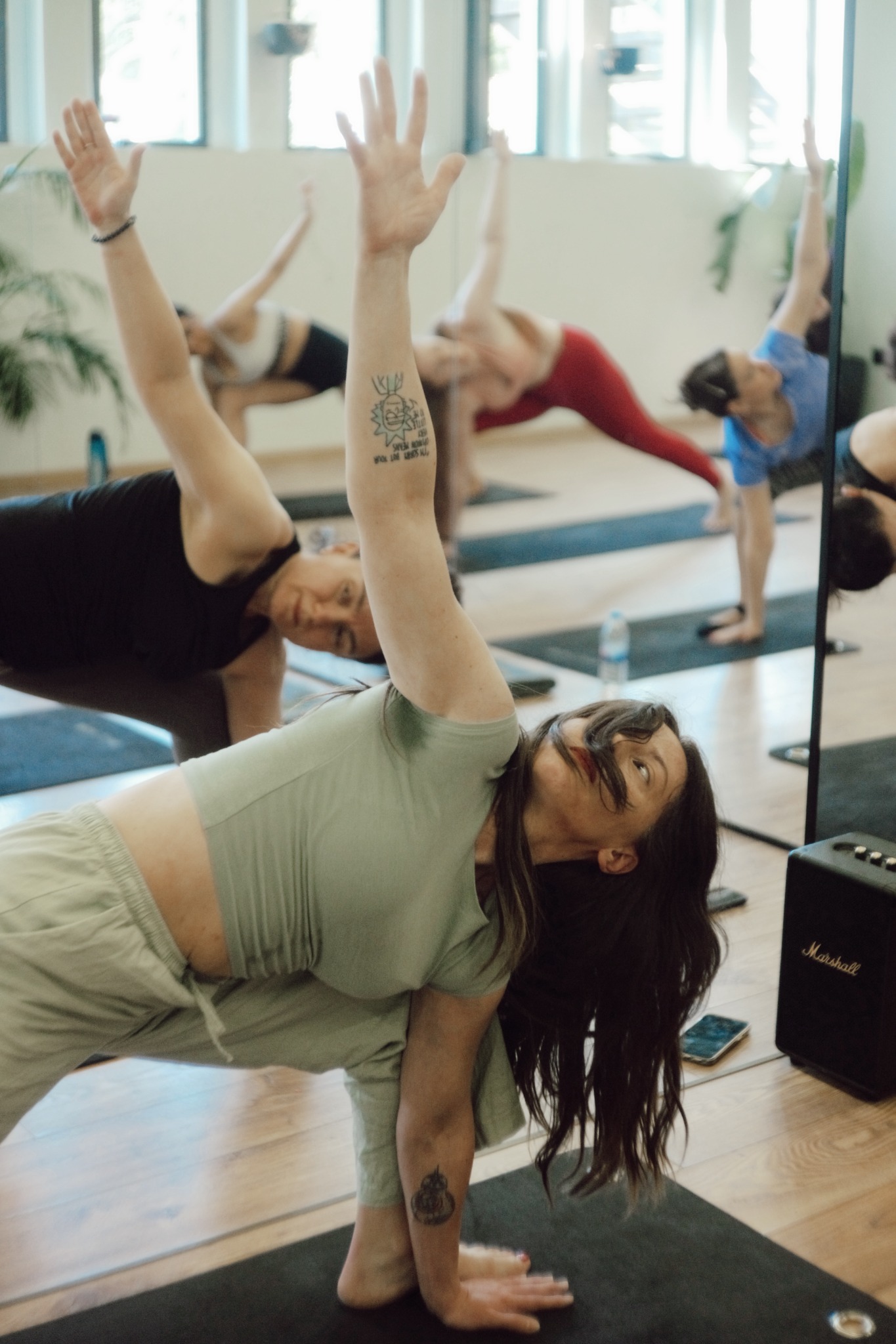 A participant opens into a side stretch as the class follows